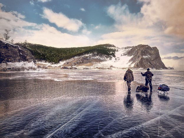People walking across ice to hill